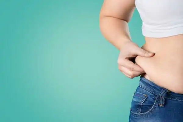 Image of woman pinching her love handles to show weight gain Lancaster